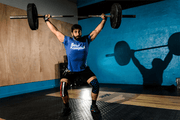man lifting over his head wearing stars and stripes knee sleeves