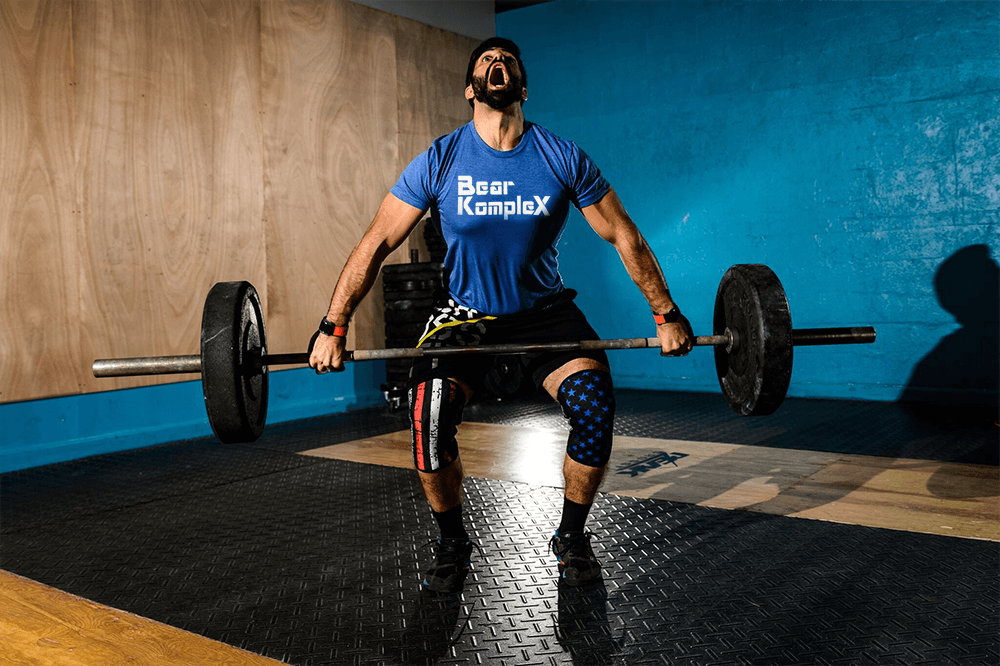 Man lifting using stars and striped knee sleeves