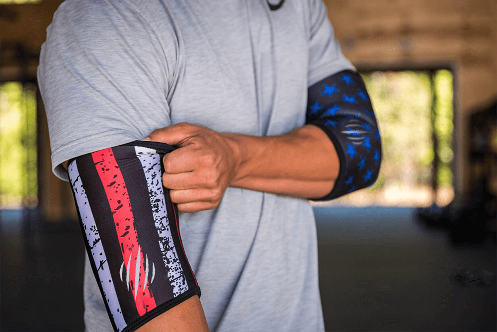 Man putting on stars and stripes elbow sleeves