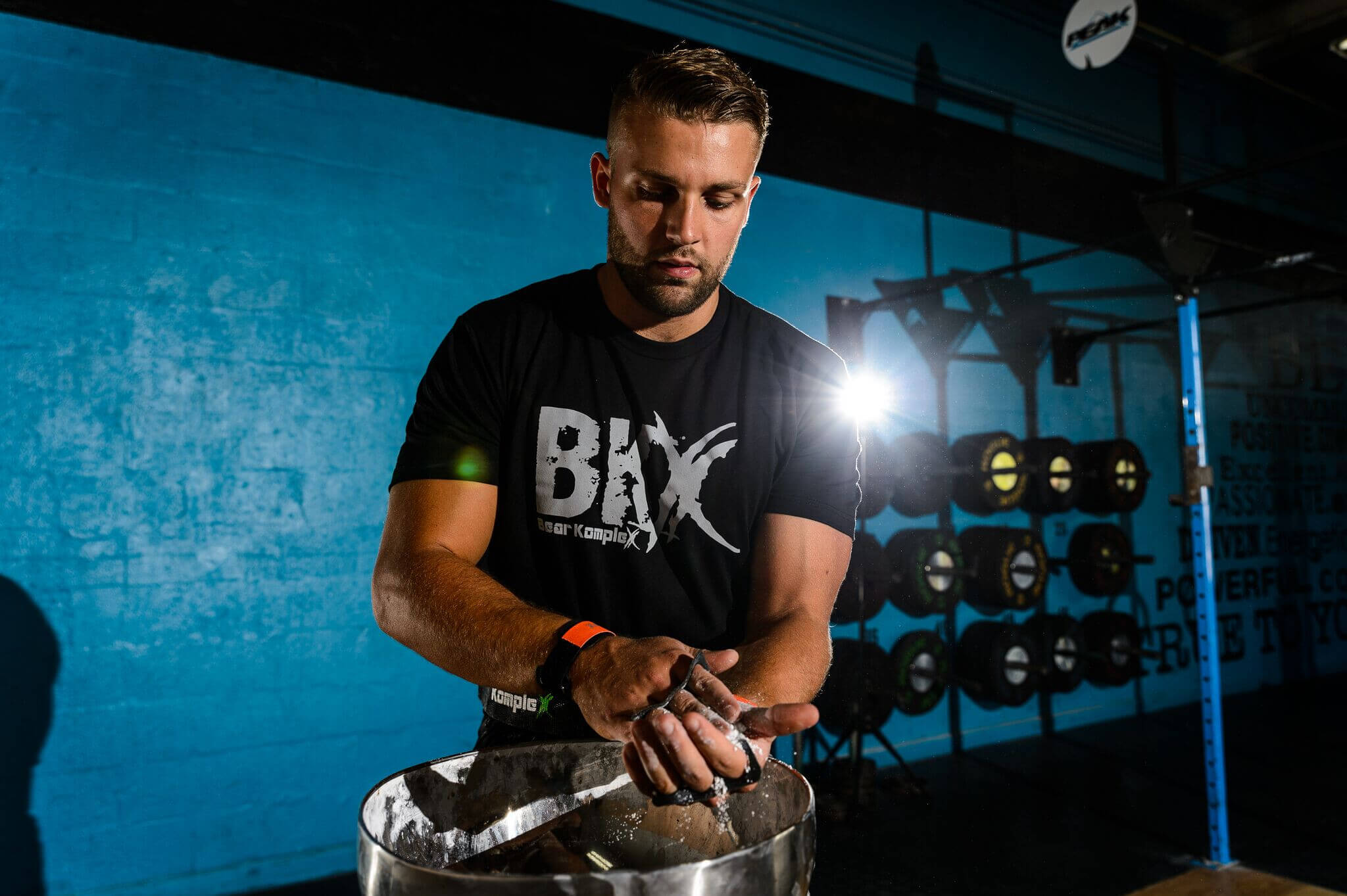 Man putting chalk on Bear KompleX Carbon Comp Grips ready to work out