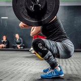 woman doing deep squats with black knee sleeves