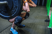 Wearing. black knee sleeves while squatting with heavy weight