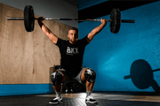 Man lifting wearing black camo knee sleeves and bear komplex shirt