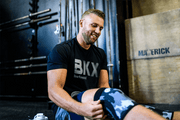 man putting on knee sleeves