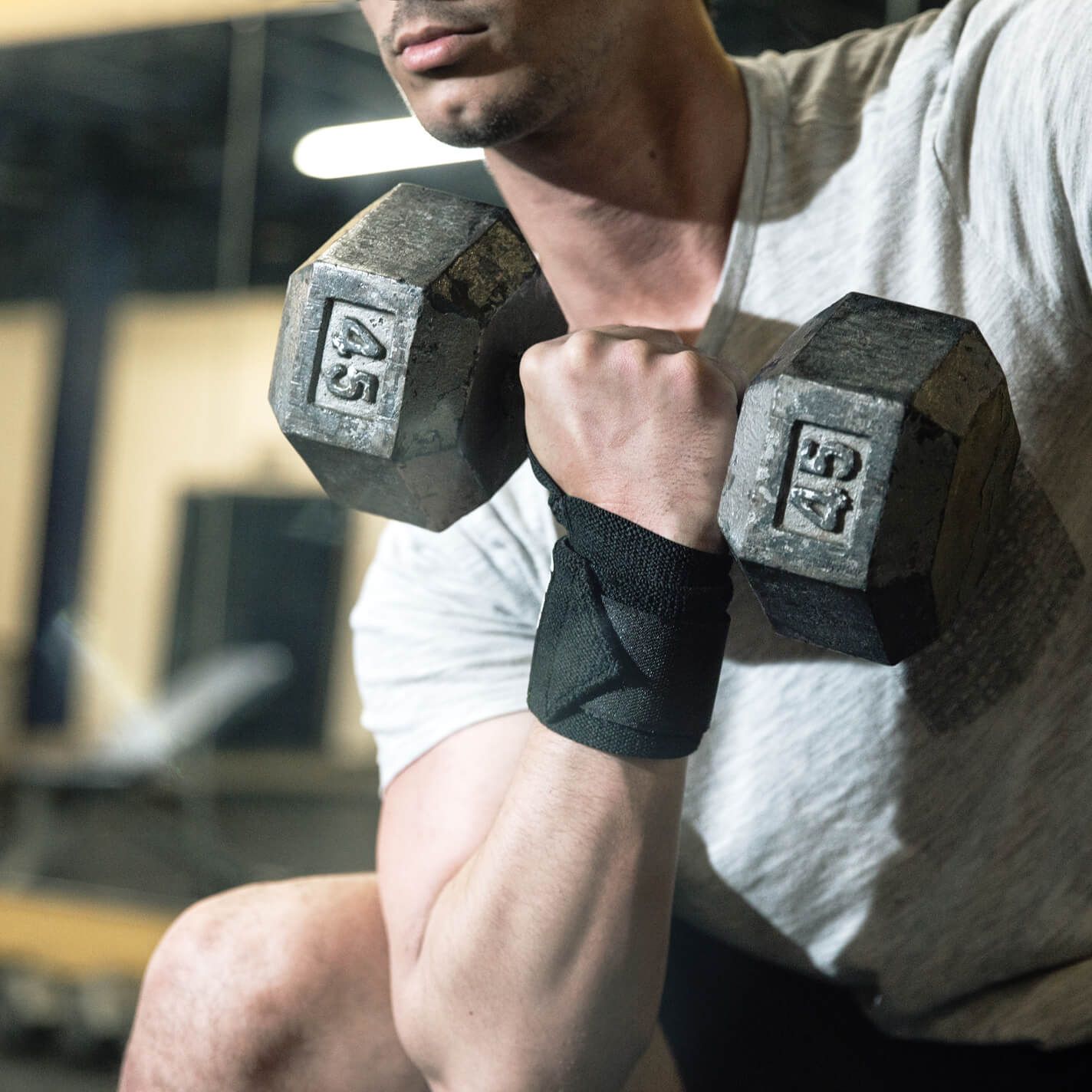 man lifting wearing Bear KompleX Wrist Wraps on barbells