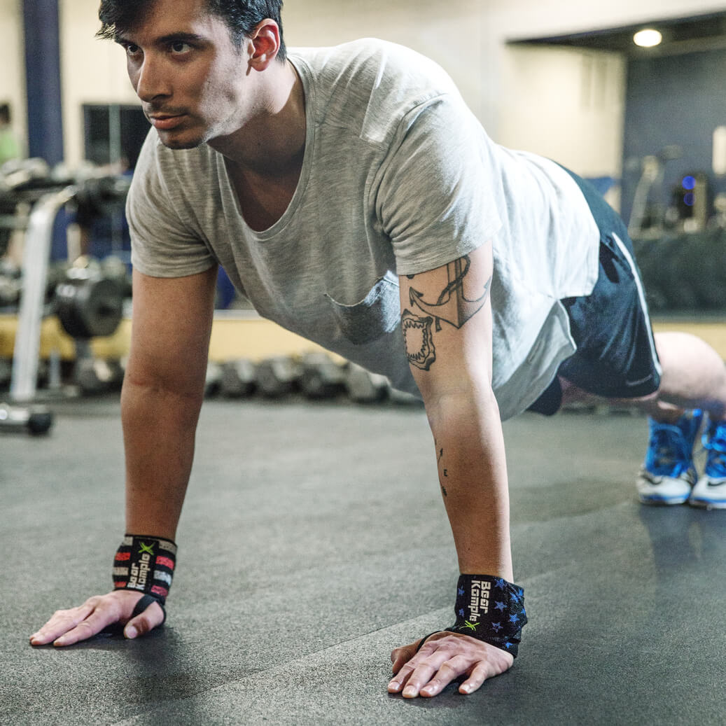 Man planking while wearing Man doing bench press with heavy barbell while wearing Bear KompleX Wrist Wraps stars and stripes