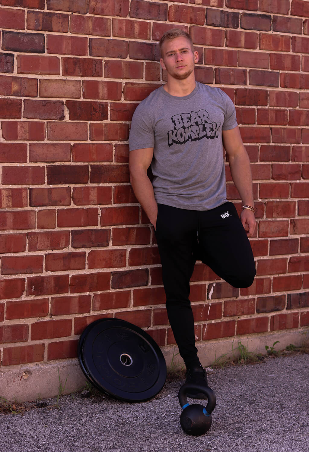 man wearing Graffiti shirt against the brick wall