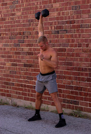 Lifting a weight above head wearing Grey Athletic Shorts