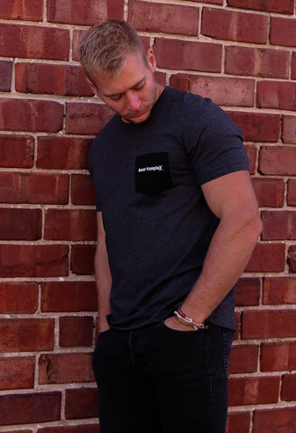 Man wearing BKX Charcoal Pocket T-Shirt Front View on brick background