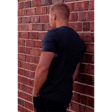 Man wearing BKX Charcoal Pocket T-Shirt back view on brick background